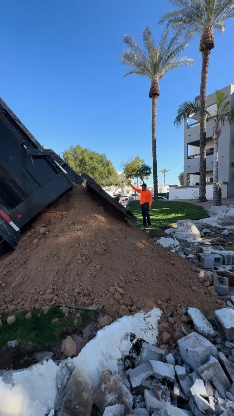 Material delivery and grading preparation at an active landscape improvement zone.