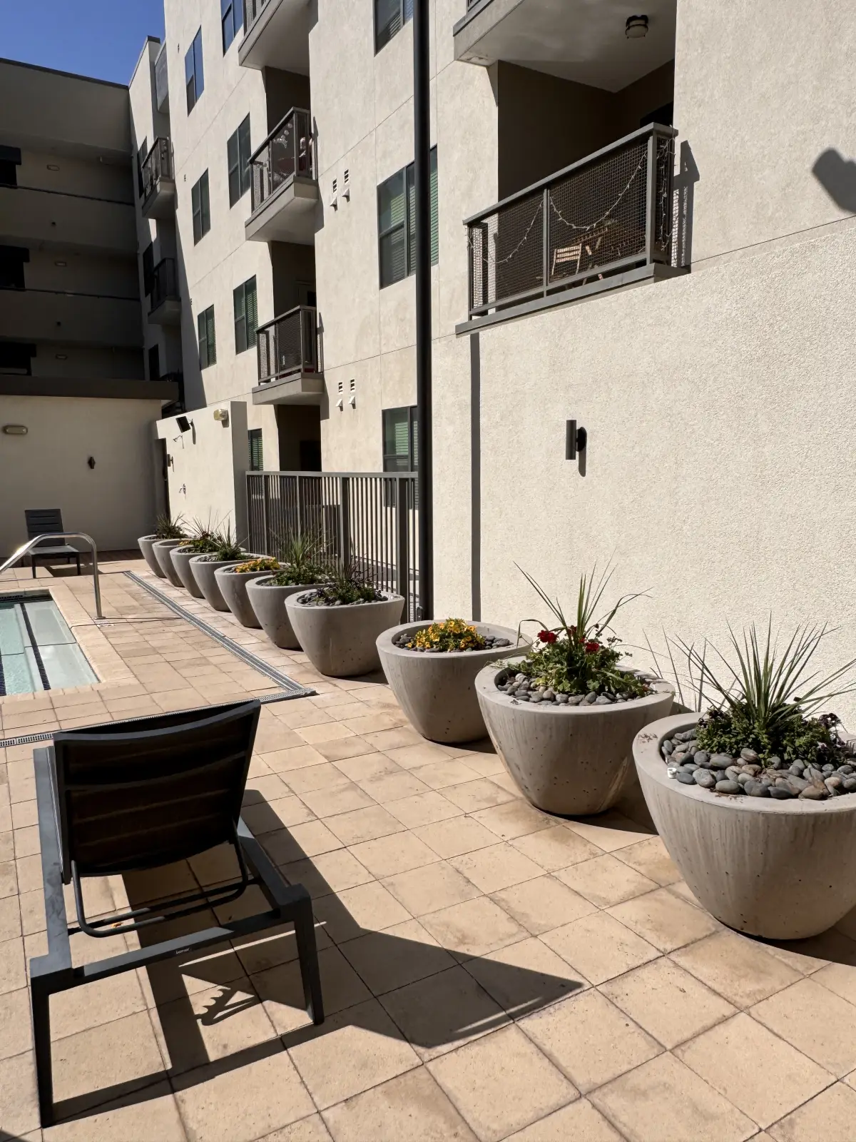 Planter row and hardscape detail around a multifamily courtyard amenity area.